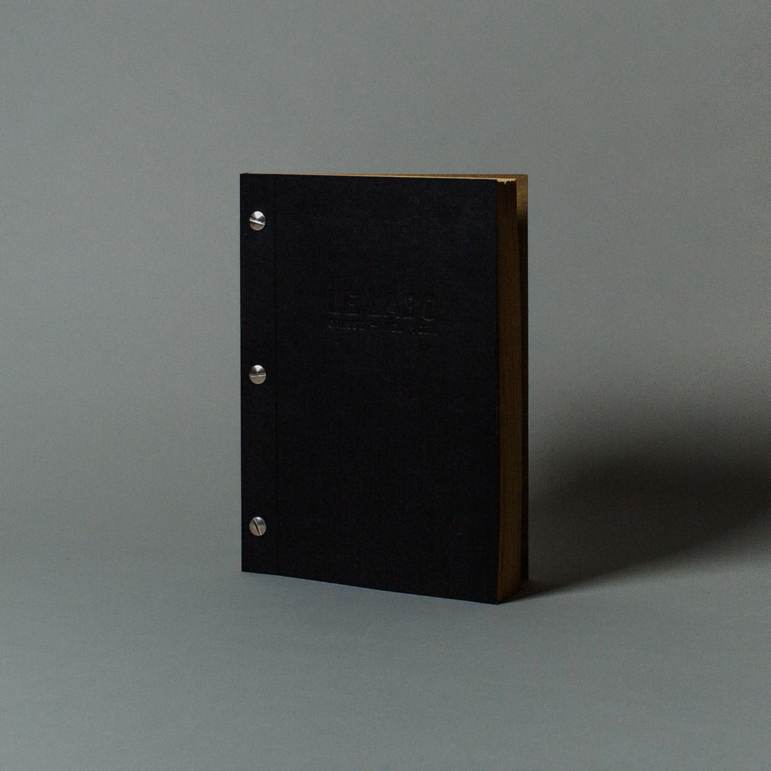 Black book with gold edges on a gray background