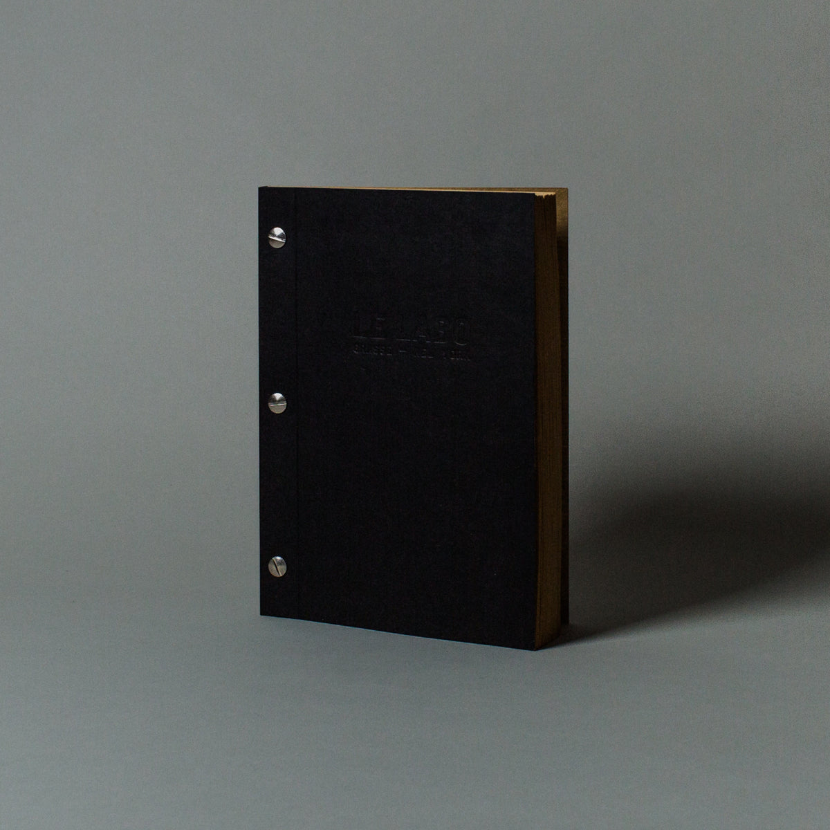 Black book with gold edges on a gray background